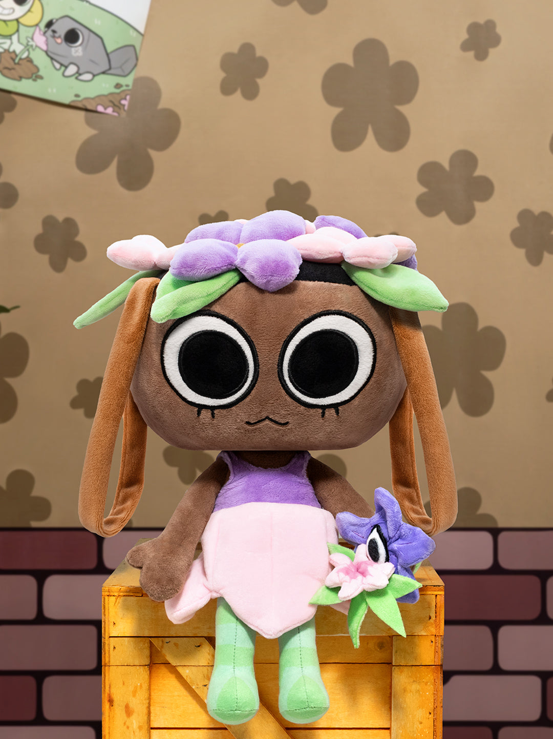 Plush toy with a brown face, purple dress, and green hair on a wooden block with a patterned background.