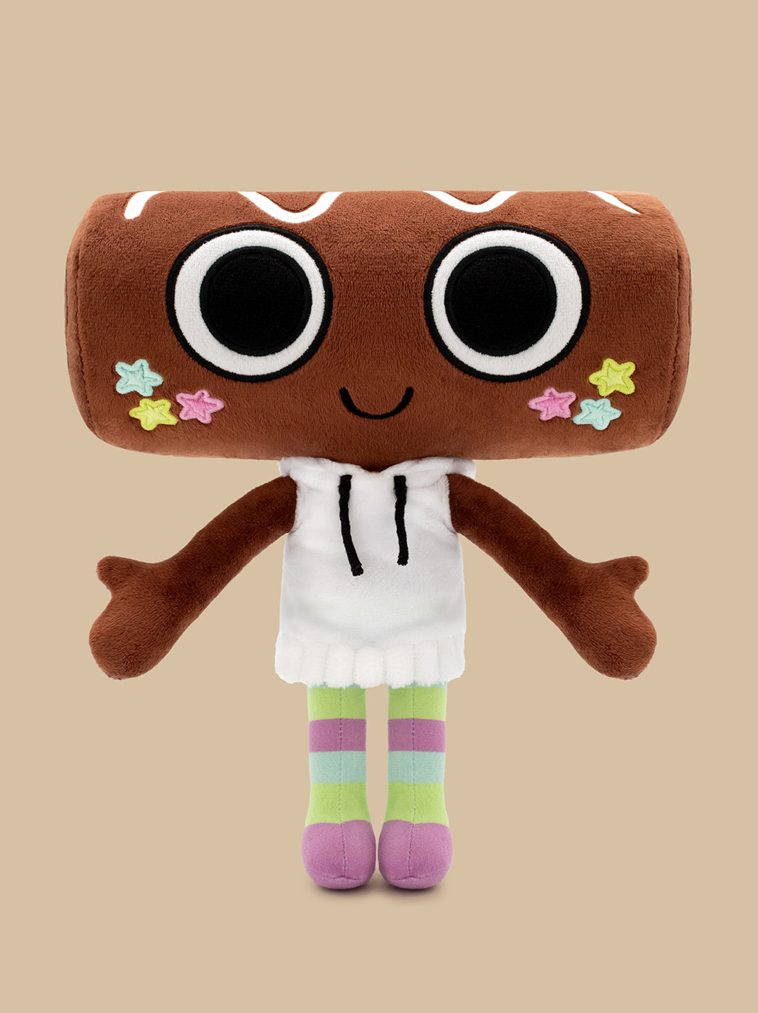A plush toy shaped like a brown donut with large cartoon eyes, a smiling mouth, colorful star accents on the cheeks, a white hoodie, and striped green, purple, and pink legs, centered on a solid beige background.