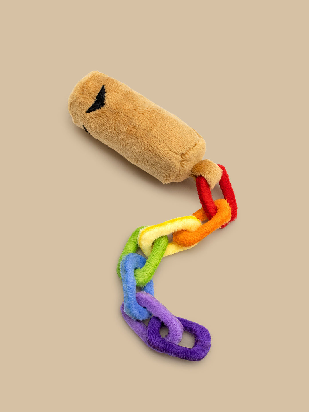 train whistle plush toy with a plush handle and colorful chain on a beige background