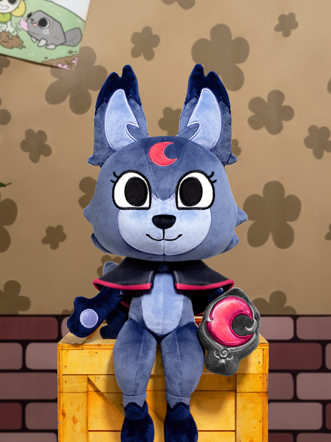 Wolf character with cape sitting on crate holding charm