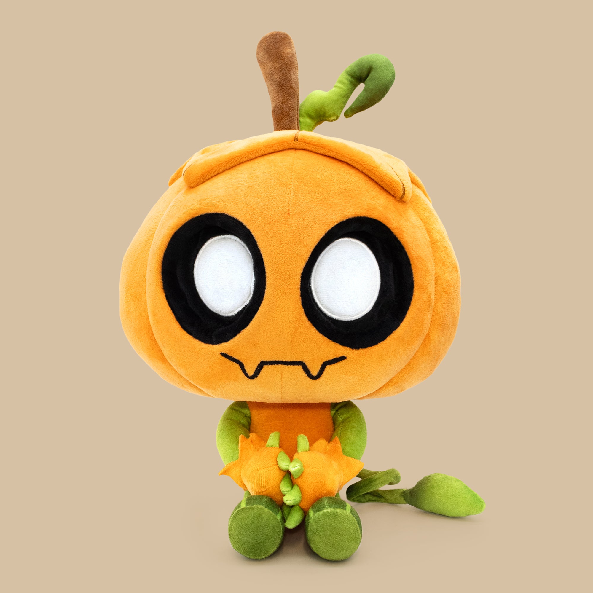 Plush toy resembling a cartoon character with an orange body, black eyes, and green limbs on a beige background