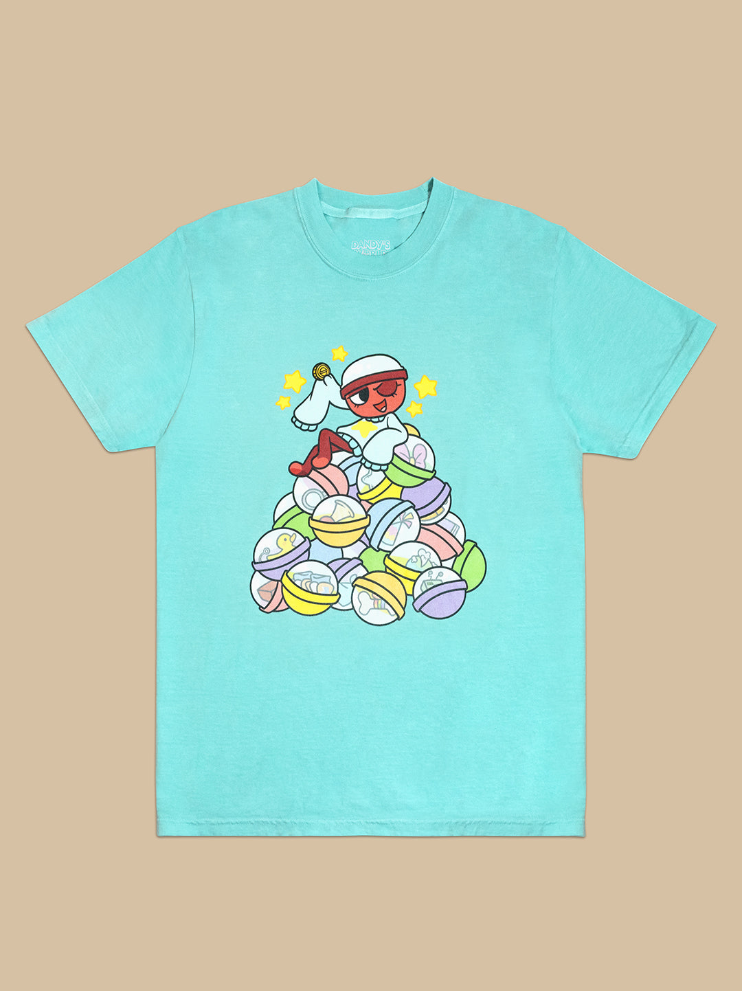 light blue t-shirt. graphic: gigi sitting on top of gachapon balls with items and trinkets inside. Holding her lucky coin with stars around her head. She's winking.