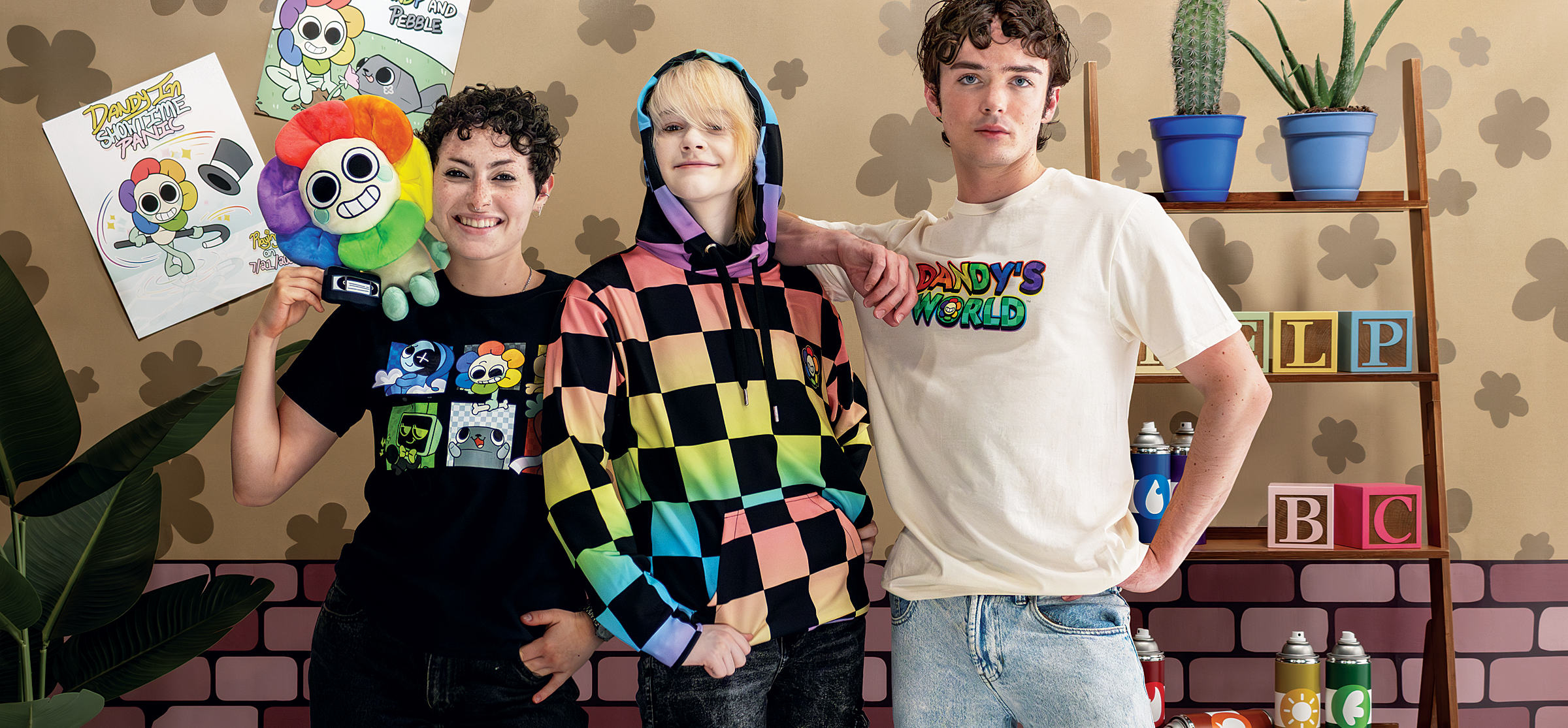 Three people standing together in a room with a colorful background and various items.