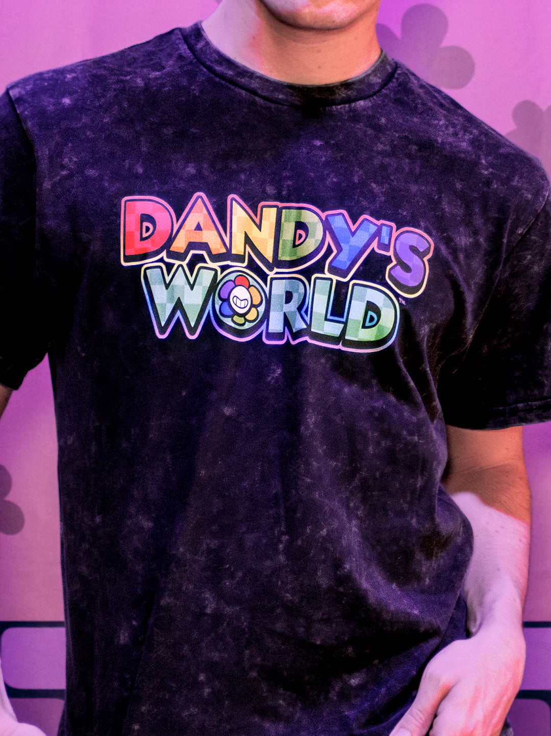 Person wearing a black t-shirt with 'Dandy's World' text in colorful letters against a purple background.