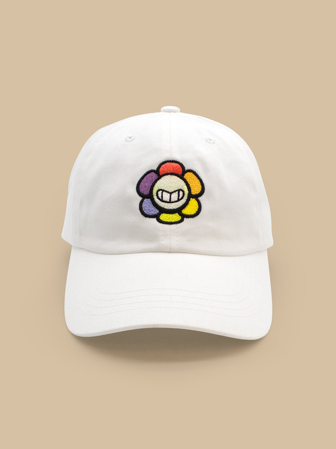 White cap with a colorful flower design on a beige background
