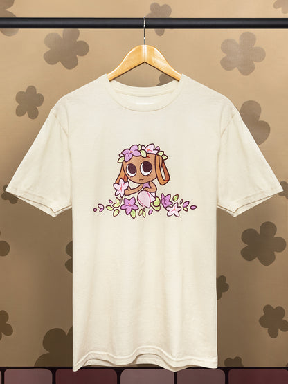 cartoon character that looks like a basket with flowers in her head and around her on a natural colored t-shirt on a hanger with a floral background.