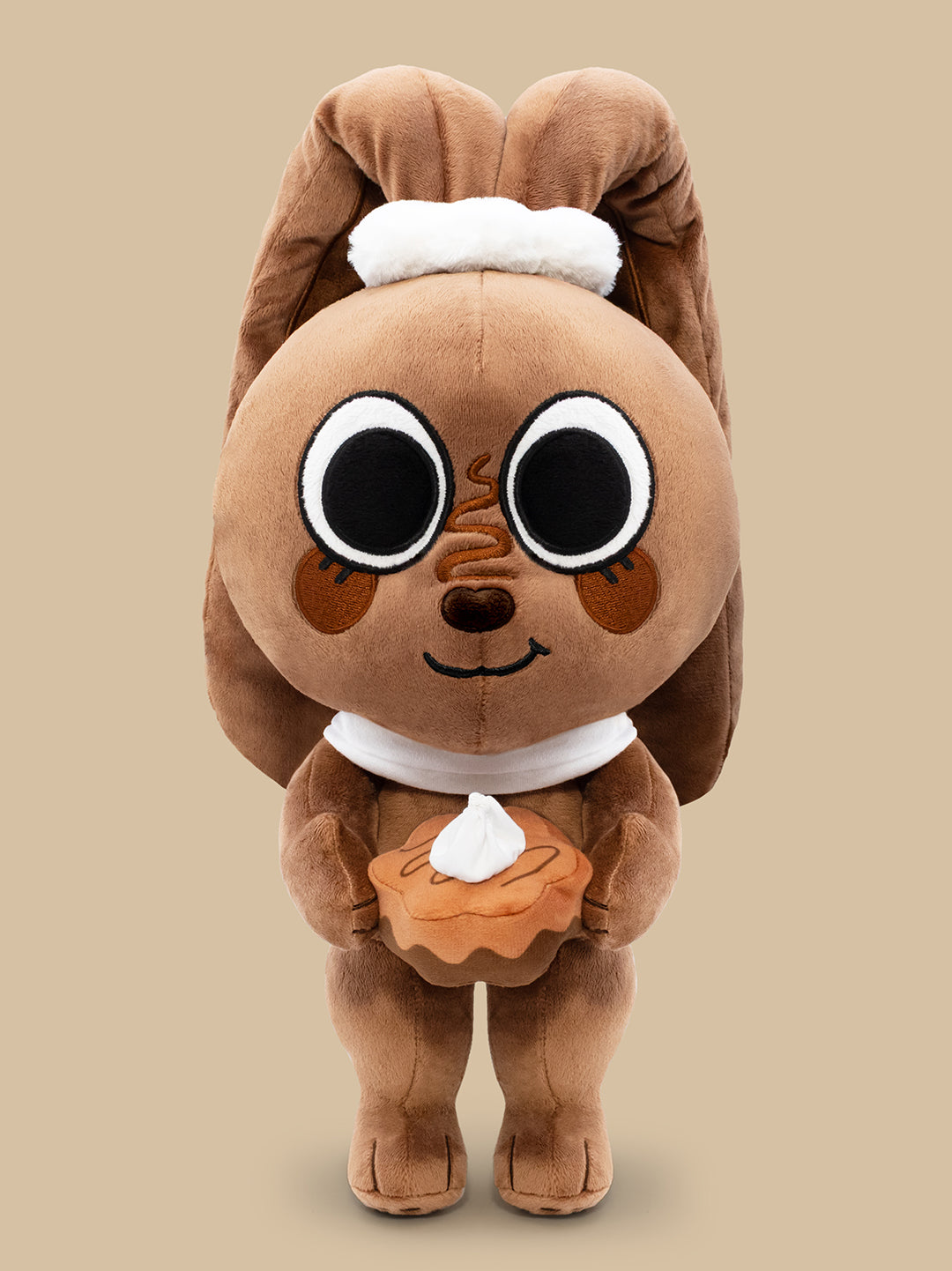 Brown plush toy with a white belly on a beige background
