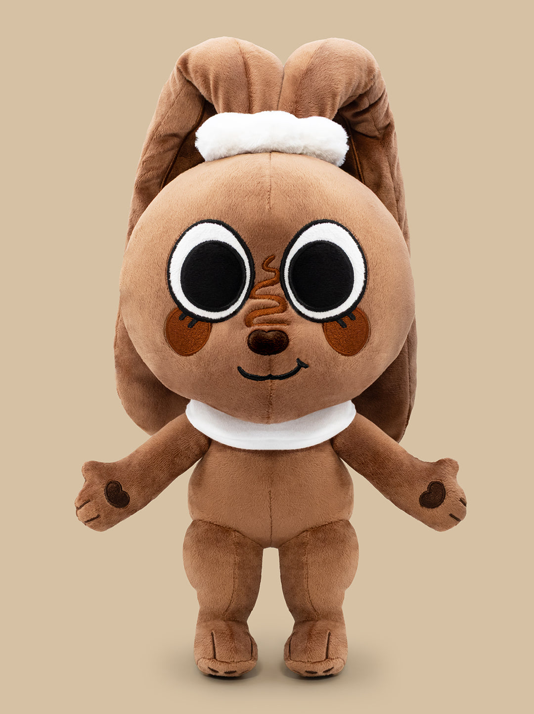 Brown plush toy with large eyes on a beige background