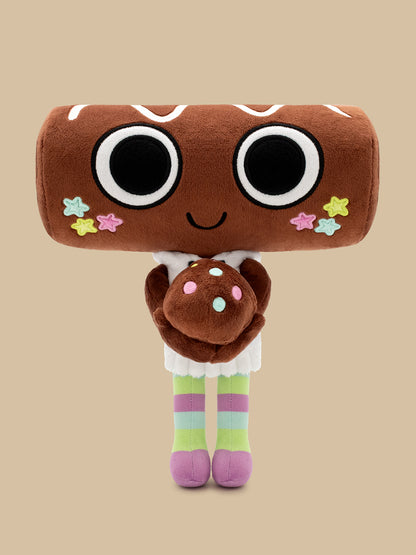 A plush toy shaped like a brown donut or cookie with oversized black-and-white eyes, a small smile, pastel star accents, and striped pastel legs, standing against a plain beige background.