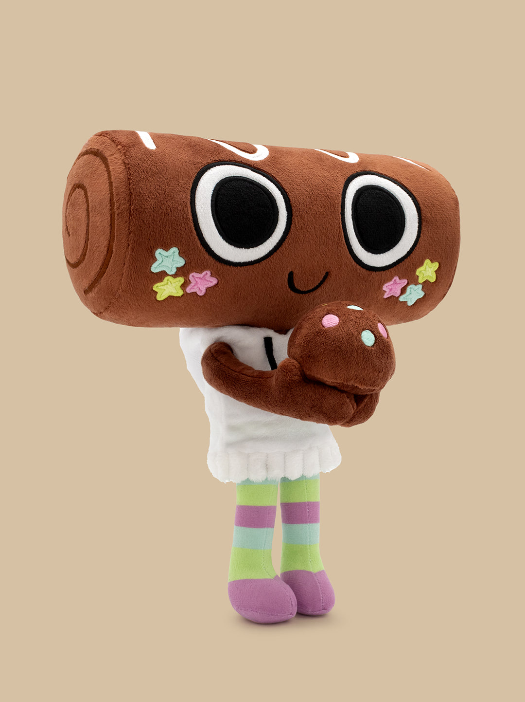 A plush toy character with a large brown log head, black-and-white eyes, a smiling face, colorful star accents, a white hoodie, and pastel striped legs, standing against a plain beige background.