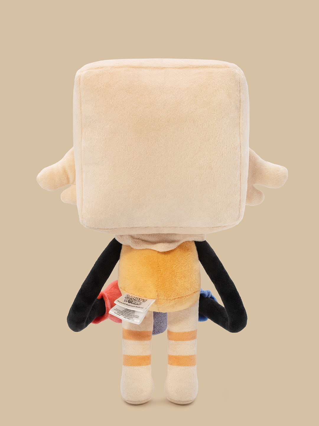 A plush toy shown from the back, featuring a large cream-colored square head, black arms, a yellow torso, and striped cream and orange legs, set against a solid beige background.