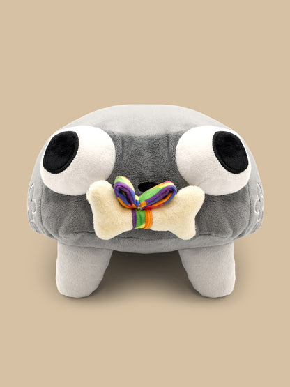 Gray plush toy with large eyes and a rainbow bone on a beige background