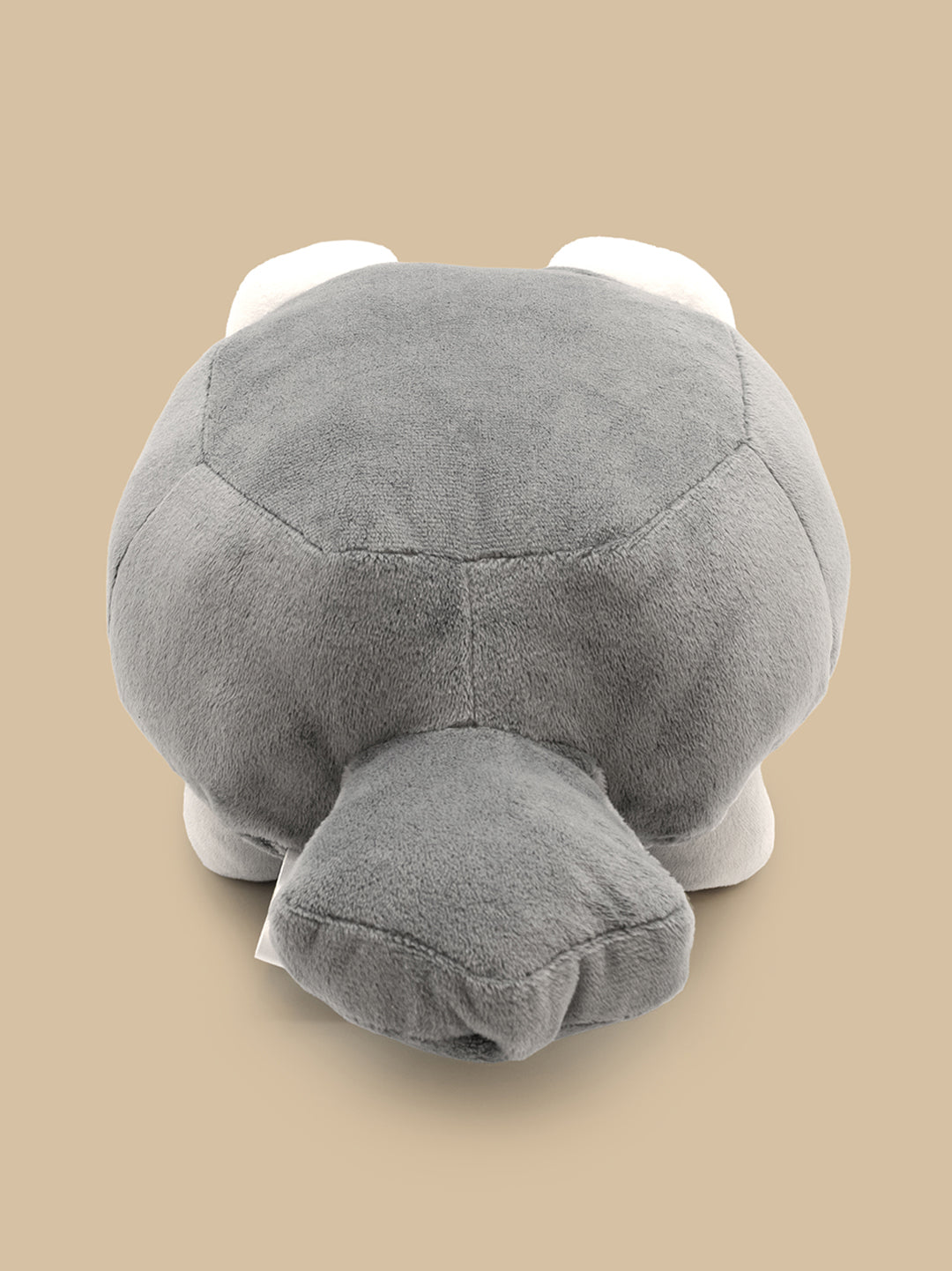 Gray plush toy resembling a turtle on a beige background