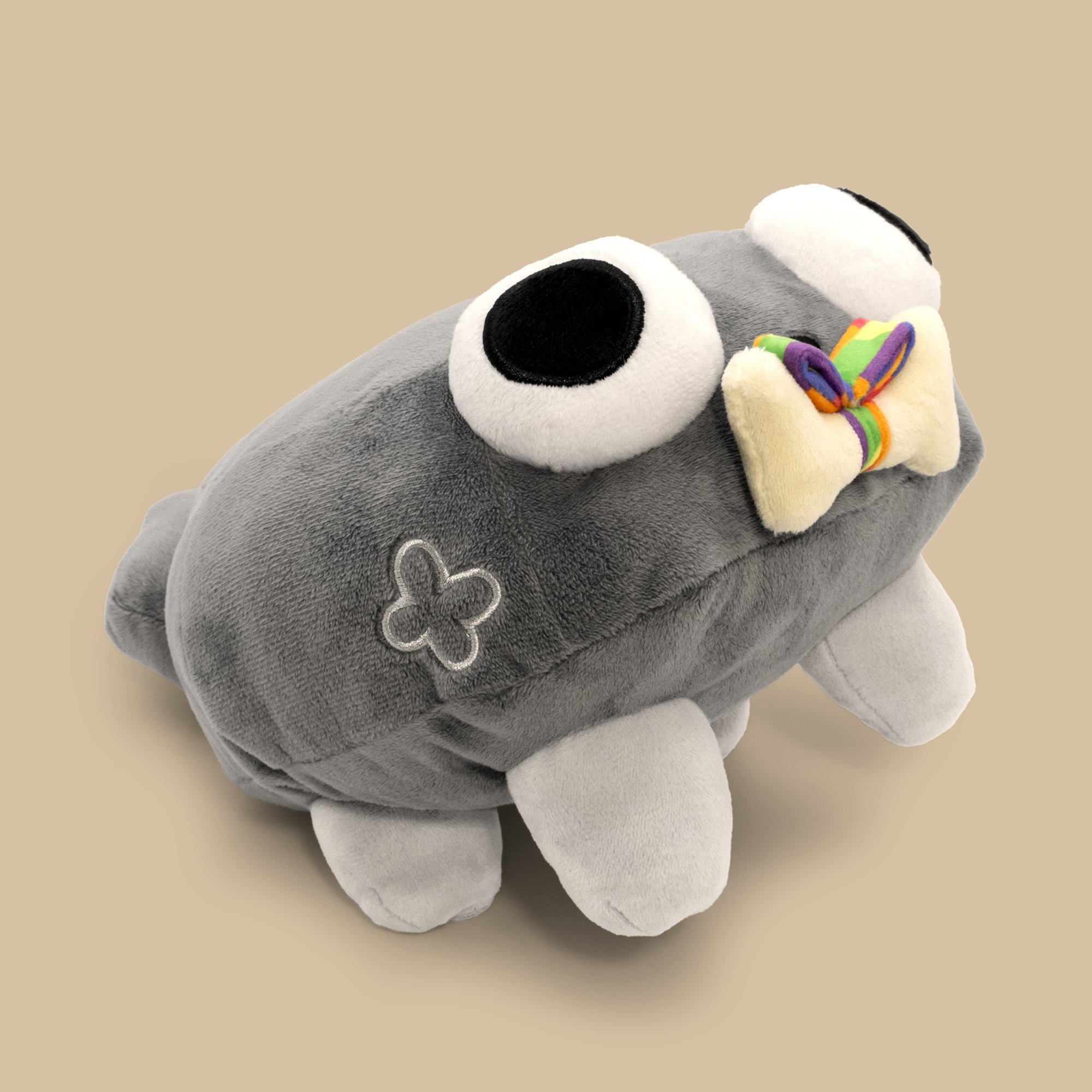 Gray plush toy with a bow on a beige background