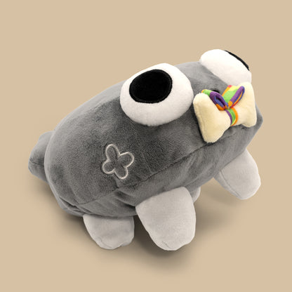 Gray plush toy with a bow on a beige background
