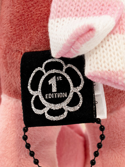 Black tag with '1st Edition' design on a pink and white checkered background