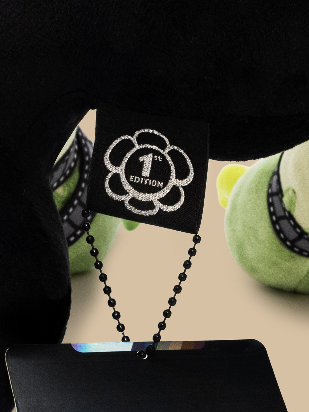 Close-up of a black and green product with a '1st Edition' tag on a beige surface.