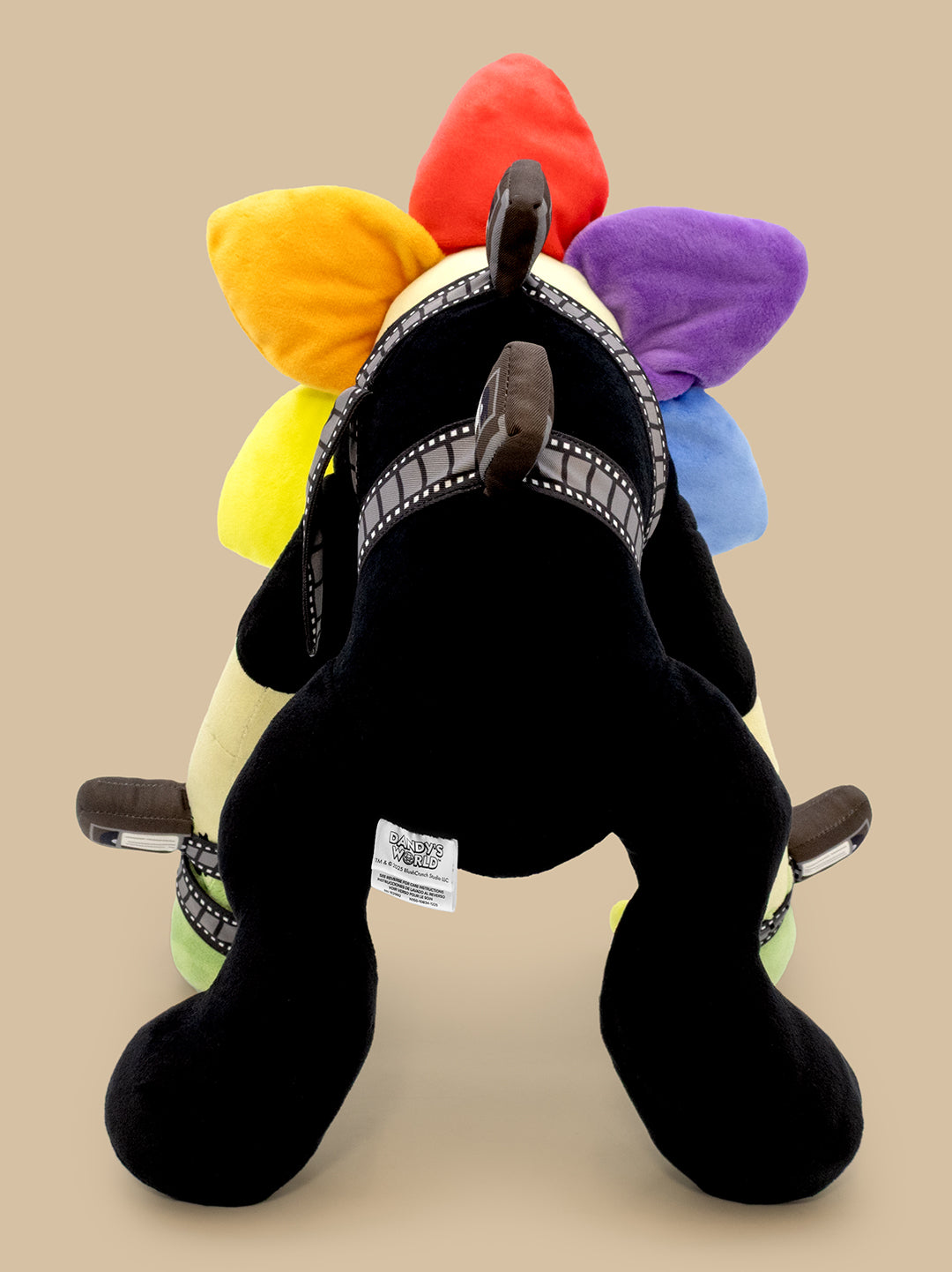 Plush toy horse with colorful mane on a beige background