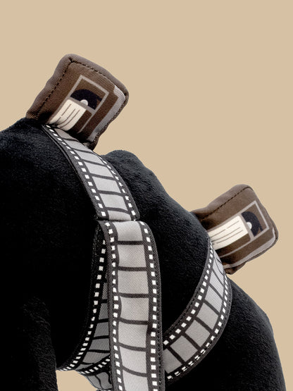 Close-up of plush with a gray and white tape reel and tapes on a beige background