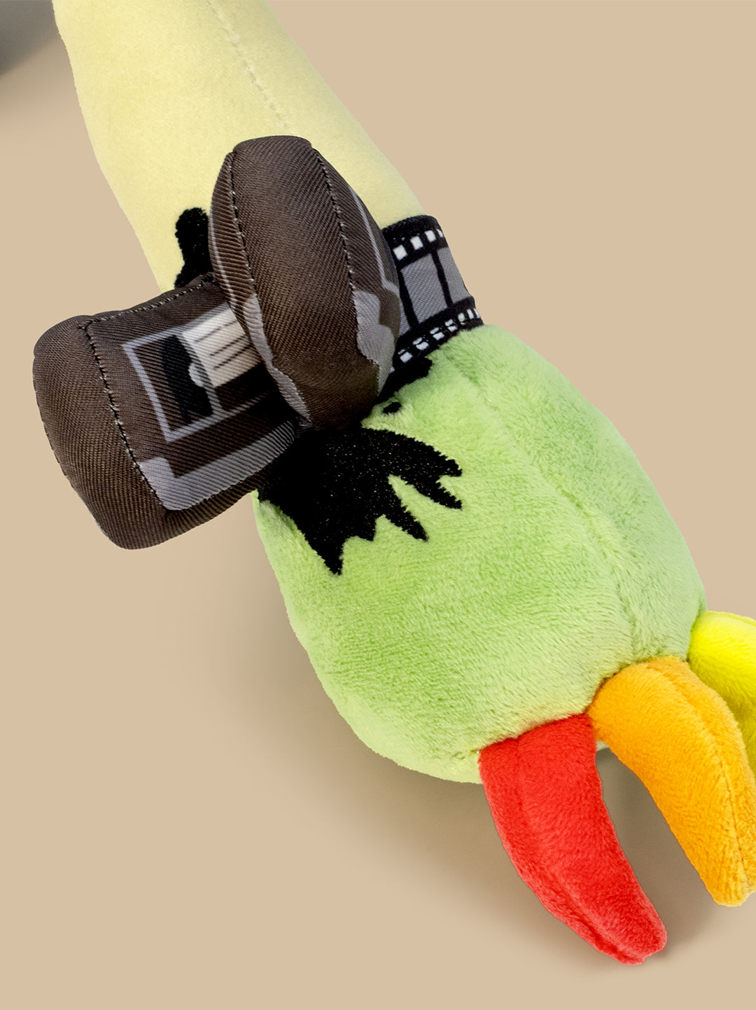 Close up of plush with tape reel around wrist on a beige surface