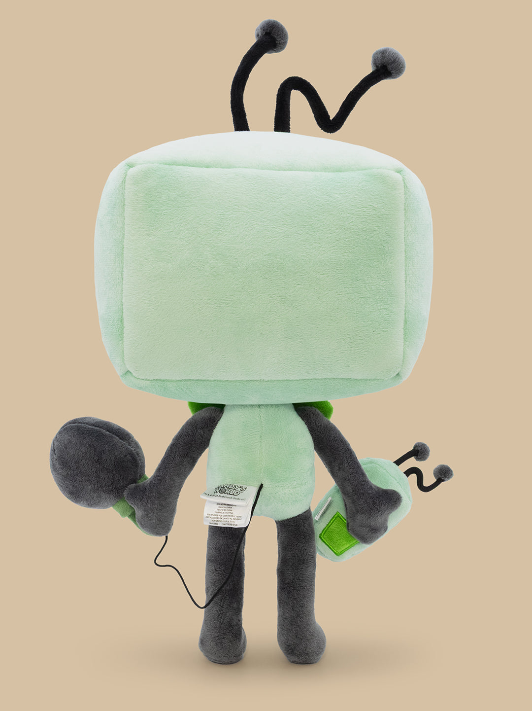 Plush toy resembling a TV with antenna on a beige background