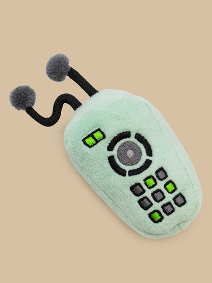 Toy remote control with pom-pom antennas on a beige background