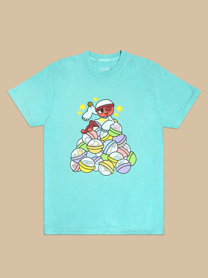 light blue t-shirt. graphic: gigi sitting on top of gachapon balls with items and trinkets inside. Holding her lucky coin with stars around her head. She's winking. 